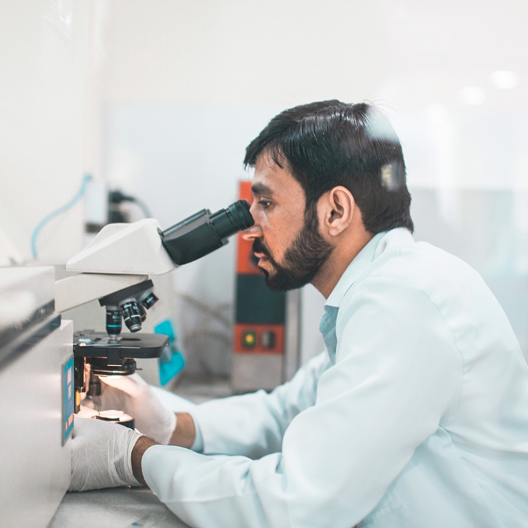 A paramedic checking slides on microscope